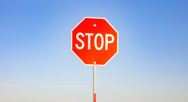 Stop sign against blue sky background. Sunny spring day