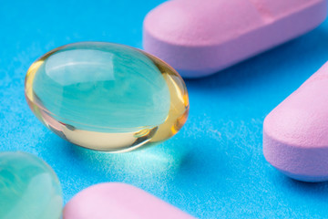 pink pills and omega3 on a blue background. omega3