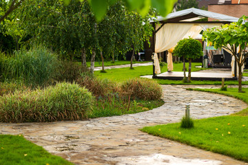 path made of natural stone among trees in landscaping