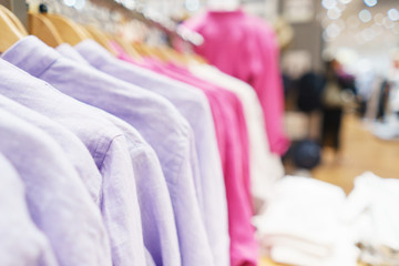 Trousers, a sweater and a hoodie on a hanger in a fashion store for youth.