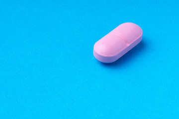 pink pills on a blue background. omega3. vitamins.