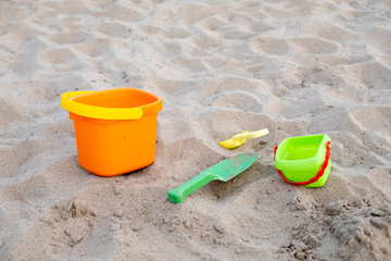 Fototapeta na wymiar Children's toys lie on the sand on the beach. Family vacation on the beach.