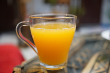 The glass cup with fresh orange juice.