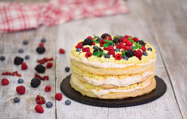 Puff pastry cake with custard and currant berries, raspberries, blackberries. Delicious dessert.