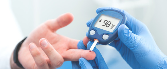 Doctor making blood sugar test in clinic