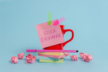 Writing note showing Stock Exchange. Business concept for An electronic market where owners of businesses get together Coffee cup pen note banners stacked pads paper balls pastel background