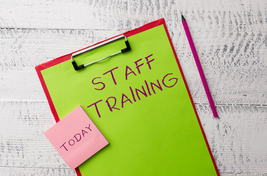 Word writing text Staff Training. Business photo showcasing A program that helps employees to learn specific knowledge Metal clipboard paper sheets marker sticky notes pad wooden background