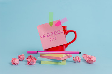 Writing note showing Valentine S Day. Business concept for time when showing show feelings of love and affection Coffee cup pen note banners stacked pads paper balls pastel background