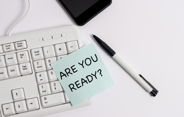 Handwriting text writing Are You Ready Question. Conceptual photo used telling someone start something when feel prepared White pc keyboard with empty note paper above white background