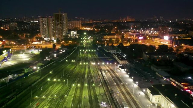 flying over the paths of the night the train station , Yekaterinburg, Russia . People and trains in the night illumination paths. 4k footage from the drone