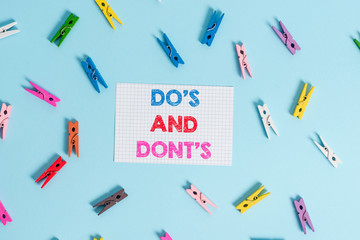 Handwriting text writing Do S Is And Dont S Is. Conceptual photo advising Rules or customs concerning some activity Colored clothespin rectangle shaped reminder paper light blue background