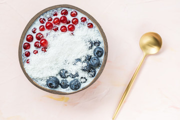 Chia seed pudding with blueberries, red currant berries and coconut flakes in a bowl