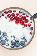 Chia seed pudding with blueberries, red currant berries and coconut flakes in a bowl