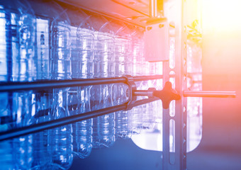 Automatic filling machine pours water into plastic PET bottles. Brewing production.