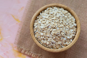 Uncooked oatmeal or oat flakes in a wooden bowl