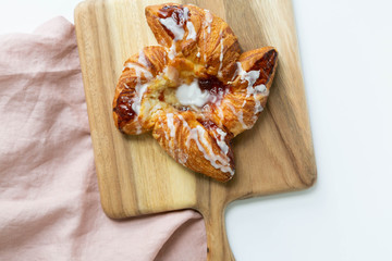 Strawberry and Sweet Cheese Danish with Icing Drizzle on Wooden Serving Board, Pink Napkin, Fruit Pastry Flat Lay on White Background