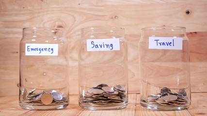 Time lapse save money coin with separate expenses for emergency, saving and travel into the glass on wood background (Thai currency, THB coin)