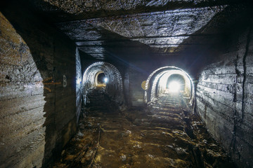 Dark dirty abandoned uranium mine with rusty remnants of railway © Mulderphoto