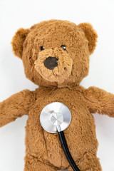 Teddy bear and stethoscope on a white background 