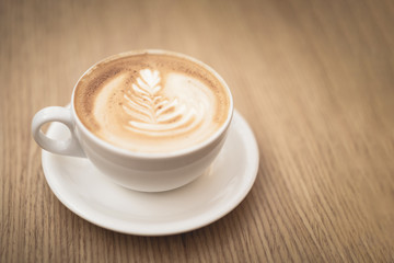 Hot coffee cappuccino latte art on wooden background