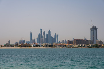 Fototapeta na wymiar DUBAI, UAE - may 2019. View of various skyscrapers including Cayan Tower in Dubai Marina with stunning turquoise waters as foreground