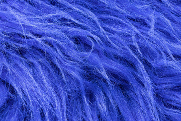 Background in the form of blue faux fur with a nap tilted to the right, close-up