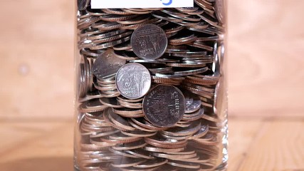 Close up save coin in the bottle glass on wood background (Thai currency, THB coin)
