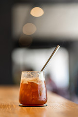 Sparkling Raspberry iced Americano coffee on wooden background with interior coffee shop.
