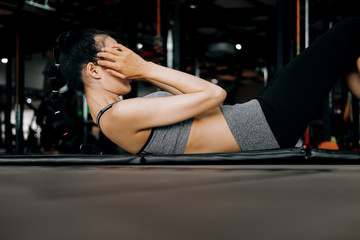 Fototapeta na wymiar sport woman at fitness gym club doing sit up exercise for body and showing muscle bodybuilding, fitness concept, sport concept
