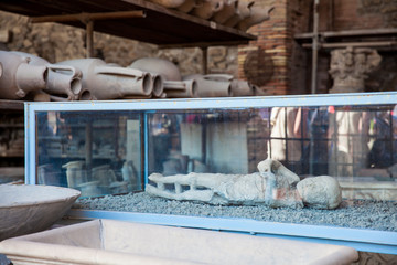 Plaster cast of a child and artifacts in the Forum Granary of the ancient city of Pompeii