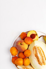 Sliced ripe juicy melon, apricots and pears on a white background. Top view.
