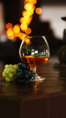 French grape brandy, strong alcoholic drink. Still life. Glass of cognac and bunch of grapes. Service and tasting concept. 