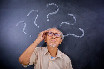 Old man thinking an idea under question marks