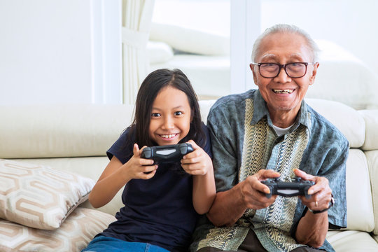 Senior man playing video games with his grandchild