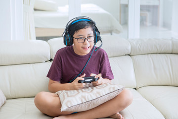 Teen boy wearing headphones to play video games