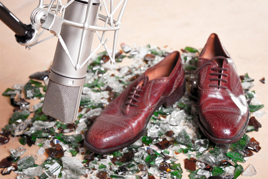 Step Foley . Male Shoes Over Broken Glass Front A Silver Professional Studio Microphone 