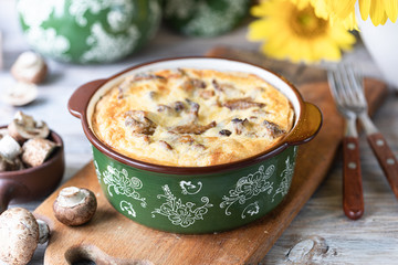 Quiche pie with mushrooms on a wooden table.