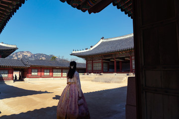 Korean lady in Hanbok or Korea dress and walk in an ancient town and Gyeongbokgung Palace in seoul, Seoul city, South Korea.