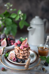 Chocolate waffles with figs, blackberries, raspberries and caramel sauce on top and mint