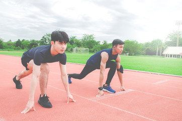 Fototapeta premium Two sportsman runners on starting position ready for competition in running at the stadium..