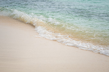 Fototapeta na wymiar Sea water washing the sandy shore with a tiny wave in the Caribbean sea