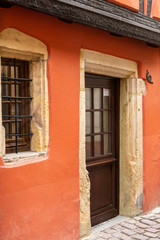 Fototapeta na wymiar Traditional entrance door and wooden window with metal grill in Colmar, France