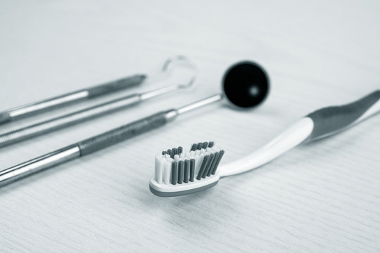 dental instruments and toothbrush on bright ground