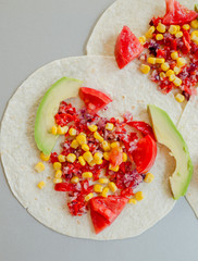 Mexican tacos with vegetarian fillings on light table, cooking process