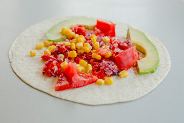 Mexican tacos with vegetarian fillings on light table, cooking process
