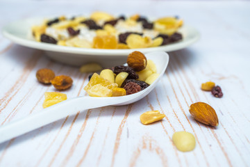 Close-up of dried fruits. Almonds, banana, cashews, pineapples on the spoon and on the plate. Health food and health eating concept.