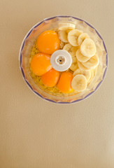Blender bowl with eggs and banana slices with cereals, eating healthy concept