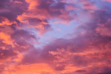 Naklejka na ściany i meble The bright orange sun rises against the backdrop of purple clouds