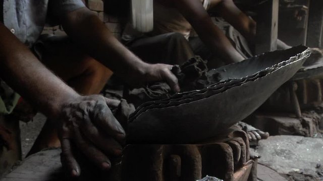 Close up shot of a mechanical power hammer shaping a metal cooking utensil in a small workshop in Punjab. Two Shot, Ground Level, Deep Focus, Fixed Shot