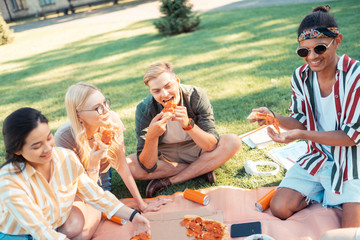 Friends telling funny stories during their picnic.